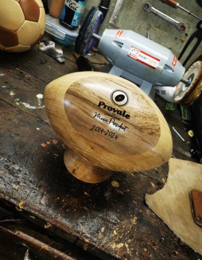 Un ballon de rugby en bois personnalisé gravé dans un atelier