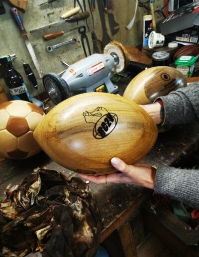 Un ballon de rugby en bois personnalisé dans une main de femme