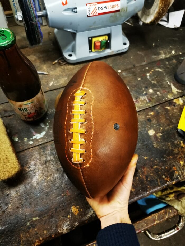 Ballon de foot Américain dans une main sur un atelier