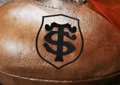 Logo du Stade Toulousain sur ballon de rugby en cuir miel