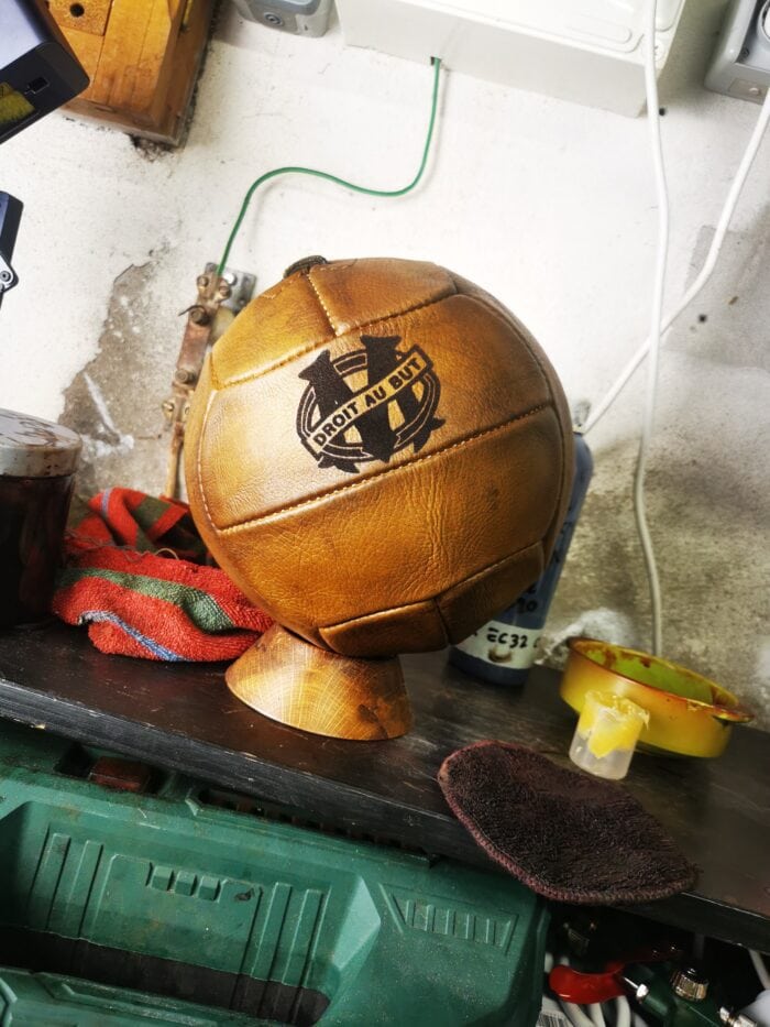 Un beau ballon de foot ancien avec le logo de l'OM gravé dessus.