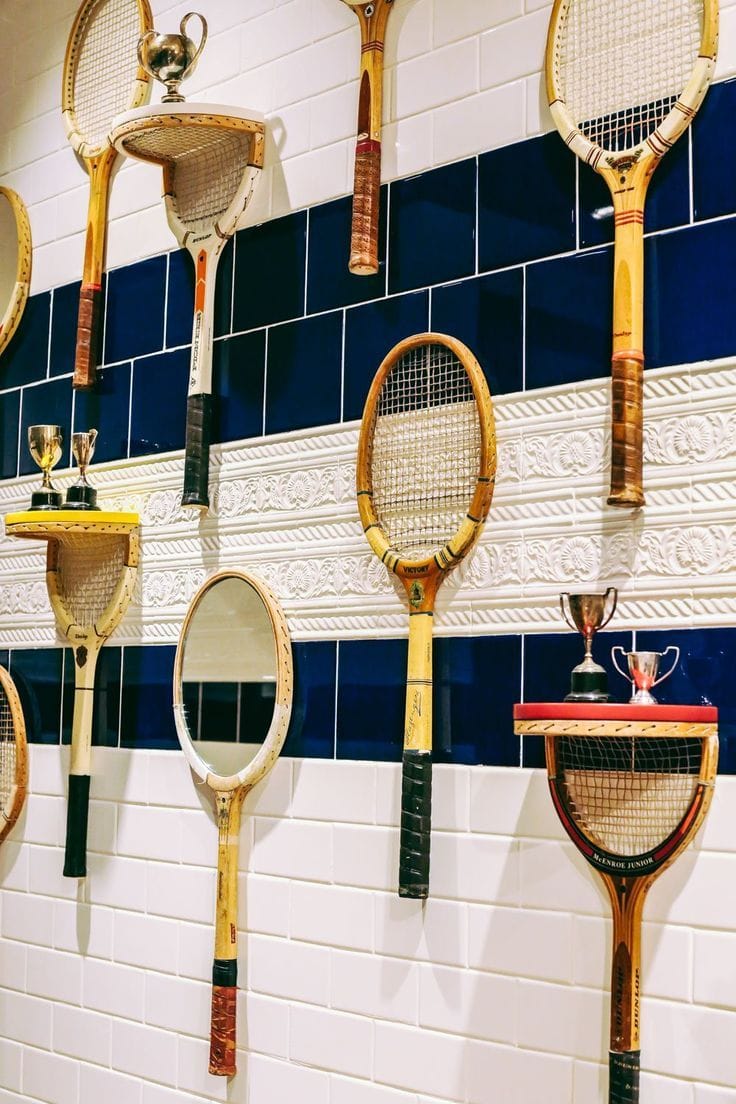 Étagères dans une salle de bain avec des raquettes de tennis en bois